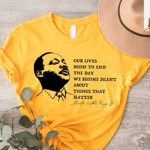 May include: Yellow t-shirt with a black and white image of Martin Luther King Jr. and a quote: "Our lives begin to end the day we become silent about things that matter. Martin Luther King Jr."