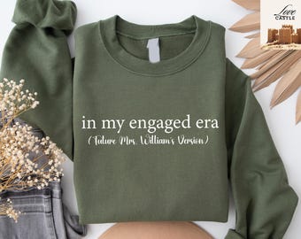 May include: A green sweatshirt with the text "in my engaged era (Future Mrs. William's Version)" printed in white.
