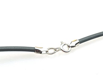 May include: Close-up of a black necklace cord with a silver-colored clasp. The clasp is a lobster claw style, and the cord appears to be made of a flexible material. The background is white.