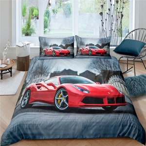 May include: Red and grey bedding set featuring a red sports car print. The set includes a duvet cover and two pillowcases.