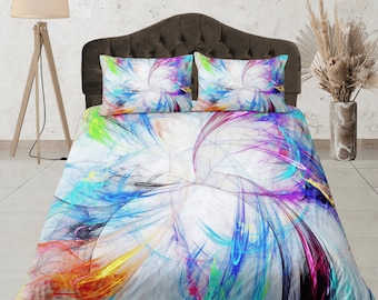 May include: A white duvet cover with a colorful abstract design featuring swirls of blue, pink, yellow, and green. The duvet cover is on a bed with two matching pillowcases.