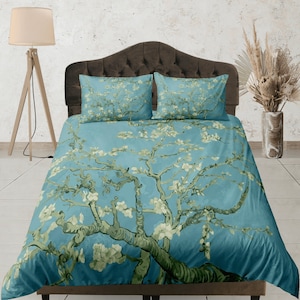May include: A blue duvet cover with a white floral pattern. The pattern features a large tree with branches and white blossoms. The duvet cover is made of soft, comfortable fabric.
