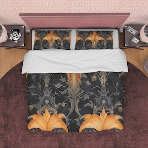 Op de afbeelding: Een zwarte en gouden dekbedovertrek met een bloemenpatroon. Het dekbedovertrek heeft een herhalend patroon van gestileerde bloemen en bladeren. Het dekbedovertrek is te zien op een bed met twee bijpassende kussenslopen.
