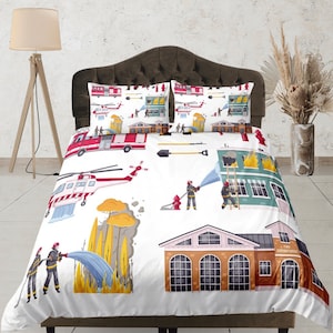 May include: White bedding set with a fire department theme. The bedding features a red fire engine, a helicopter, firefighters, and a burning building. The text "Fire Department" is printed on the bedding.