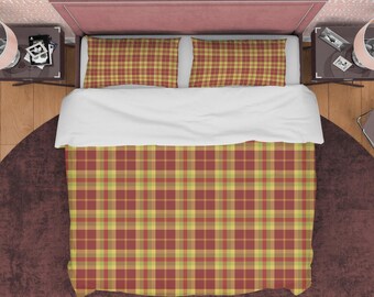May include: A red, yellow, and green plaid duvet cover with matching pillowcases. The duvet cover is on a bed with a white comforter and a pink headboard.