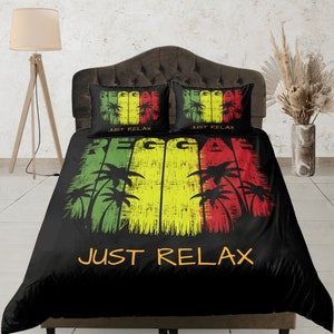 Puede incluir: Juego de cama negro y verde con temática reggae. La funda nórdica presenta un diseño amarillo, verde y rojo con palmeras y las palabras "Reggae" y "Just Relax".