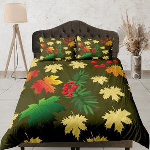 May include: A green, yellow, and red patterned duvet cover with a leafy design. The duvet cover features a variety of leaves, including maple leaves, oak leaves, and berries.
