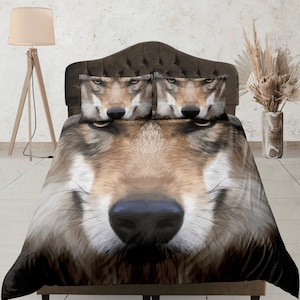 May include: A bedding set featuring a close-up image of a wolf's face. The set includes a duvet cover and two pillowcases, all displaying the wolf's detailed fur and piercing gaze. The color palette is dominated by browns, tans, and blacks.