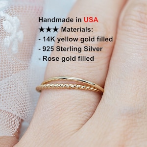 May include: Two gold rings on a finger. The top ring is a simple band, and the bottom ring is a twisted band. The text on the image reads: "Handmade in USA ★★ Materials: - 14K yellow gold filled - 925 Sterling Silver - Rose gold filled"