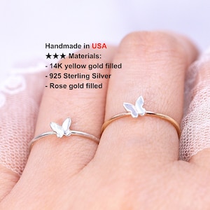 May include: Two delicate rings with a butterfly design. The ring on the left is silver and the ring on the right is gold. Handmade in the USA. Materials: 14K yellow gold filled, 925 Sterling Silver, Rose gold filled.
