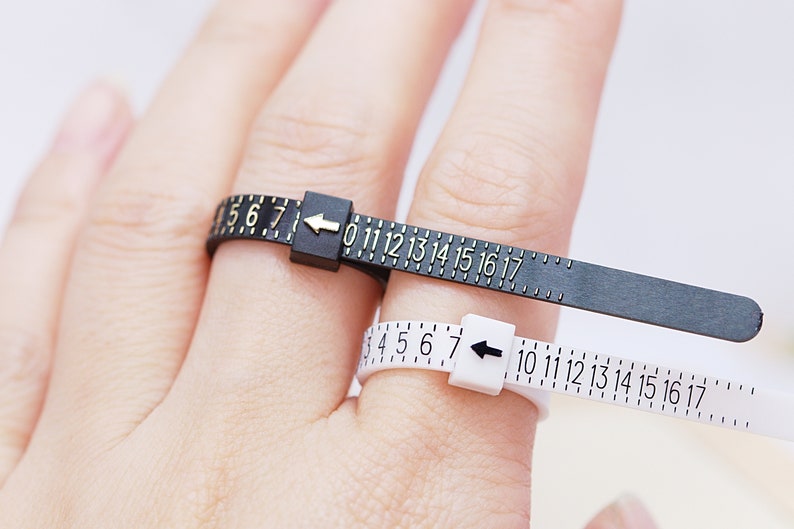 Puede incluir: Dos medidores de anillos, uno negro y otro blanco, con escalas numeradas. El medidor negro tiene n&uacute;meros dorados, el blanco tiene n&uacute;meros negros. Miden tallas de anillos, del 4 al 17.