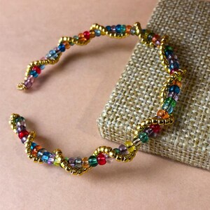 Armband aus Memory-Draht mit mehrfarbigen Glasperlen. Schöne Farben, perfekt für Fairycore, Goblincore, Partys und Feiertage. Leicht anzulegen.