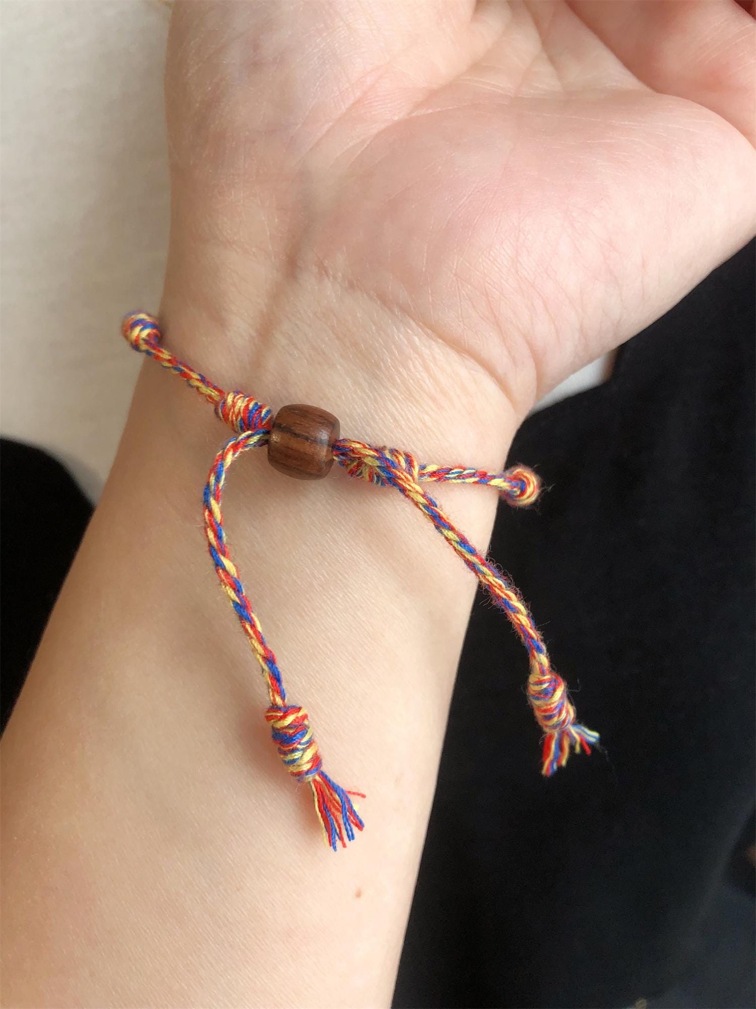 綿紐に7つの結び目があるお守りブレスレット。チベットの編み糸で作
