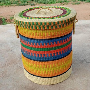 May include: A colourful woven storage basket with a lid. The basket is made of natural materials and has a striped pattern in shades of blue, orange, yellow, green, and red.