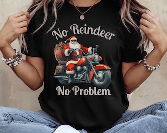 May include: Black t-shirt featuring Santa Claus riding a red motorcycle with the text "No Reindeer No Problem". Santa is wearing a red suit and sunglasses, with a bag of gifts on the back of the bike. The design is a fun, festive take on Christmas.