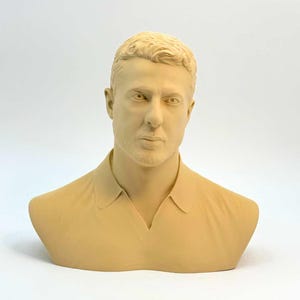 Könnte beinhalten: Hellbeige Büstenskulptur eines Mannes mit kurzen, hellen Haaren und einem kurzen Bart. Die Skulptur zeigt den Mann mit einem Hemd mit Kragen. Die Büste ist vor einem schlichten weißen Hintergrund platziert.