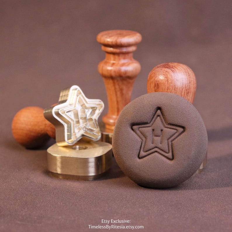 May include: A brass wax seal stamp featuring a star-shaped head with a wooden handle, accompanied by a circular brown wax impression displaying a star outline and the letter H in the center. Text at the bottom reads: Etsy Exclusive: TimelessByRitesia.etsy.com.