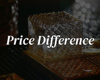 May include: A close-up of a clear glass cube with a textured surface. The cube is sitting on a brown surface with the text "Price Difference" in white.