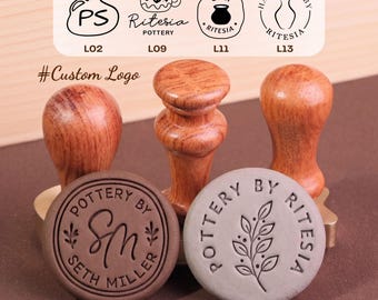 May include: Three wooden stamps with rounded handles and circular brass bases. Two circular clay impressions are in the foreground: one brown with the text Pottery By Seth Miller and one gray with a leaf design and Pottery By Ritesia text.