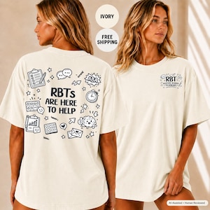 Può includere: Una t-shirt a maniche corte color avorio con grafiche a linee nere. Il retro mostra il testo RBTS ARE HERE TO HELP circondato da icone di appunti, orologio, cervello e fumetti. Il petto presenta un piccolo logo RBT.