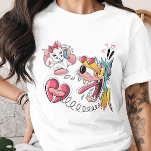May include: White t-shirt featuring cartoon graphics. The design includes a pink broken heart with a bandage, a cat with a bow, and a wolf with hearts for eyes. The text "MAKE THE DUH" is also present.