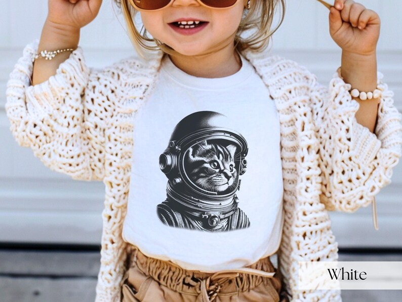 Adorable Space Cat Shirt featuring a cute kitty in an astronaut helmet, perfect for kids outer space birthday celebrations. This galaxy cat shirt makes a great gift for young space enthusiasts