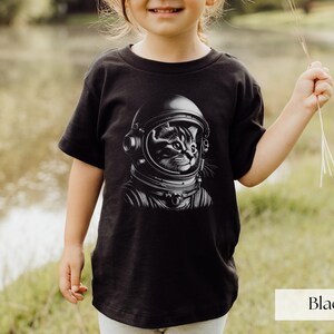 Adorable Space Cat Shirt featuring a cute kitty in an astronaut helmet, perfect for kids outer space birthday celebrations. This galaxy cat shirt makes a great gift for young space enthusiasts