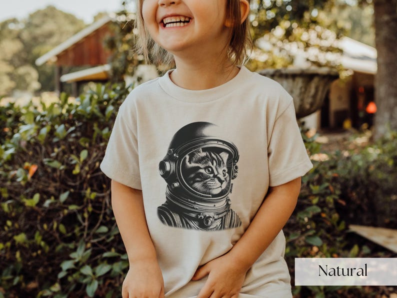 Adorable Space Cat Shirt featuring a cute kitty in an astronaut helmet, perfect for kids outer space birthday celebrations. This galaxy cat shirt makes a great gift for young space enthusiasts