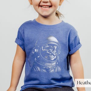 Adorable Space Cat Shirt featuring a cute kitty in an astronaut helmet, perfect for kids outer space birthday celebrations. This galaxy cat shirt makes a great gift for young space enthusiasts