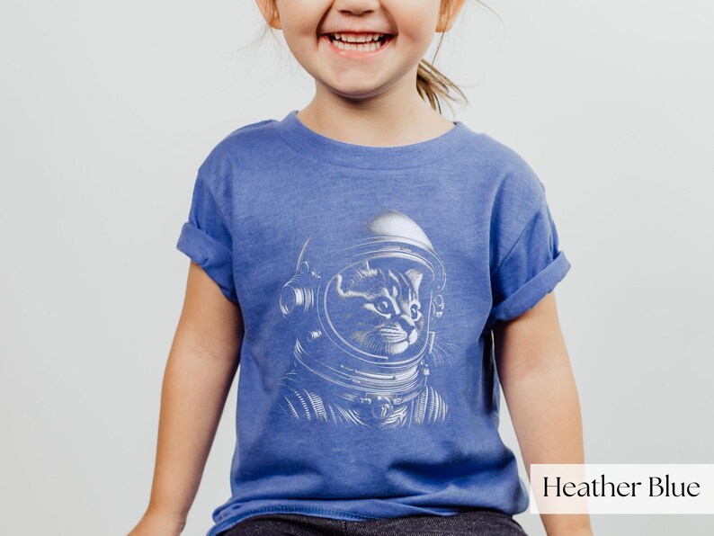 Adorable Space Cat Shirt featuring a cute kitty in an astronaut helmet, perfect for kids outer space birthday celebrations. This galaxy cat shirt makes a great gift for young space enthusiasts