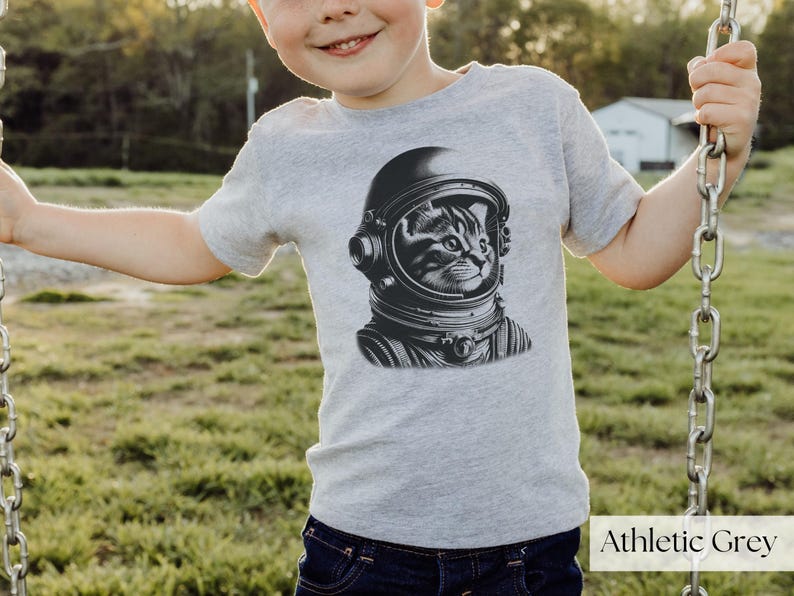 Adorable Space Cat Shirt featuring a cute kitty in an astronaut helmet, perfect for kids outer space birthday celebrations. This galaxy cat shirt makes a great gift for young space enthusiasts