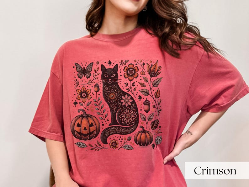 Woman wearing red Black Cat Halloween shirt featuring a spooky black cat, pumpkins, fall leaves, and flowers. Perfect for autumn and spooky season. Ideal for Halloween parties or as a cat lover gift with a vintage floral and witchy aesthetic.