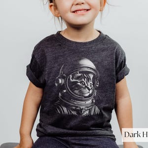 Adorable Space Cat Shirt featuring a cute kitty in an astronaut helmet, perfect for kids outer space birthday celebrations. This galaxy cat shirt makes a great gift for young space enthusiasts