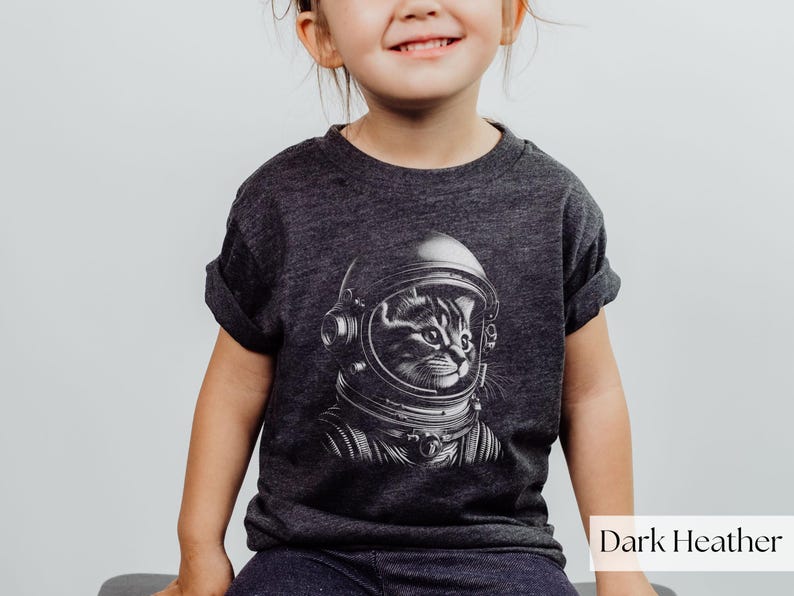 Adorable Space Cat Shirt featuring a cute kitty in an astronaut helmet, perfect for kids outer space birthday celebrations. This galaxy cat shirt makes a great gift for young space enthusiasts