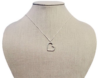 May include: A silver necklace with a heart-shaped pendant. The pendant is open in the center, creating a double heart design.
