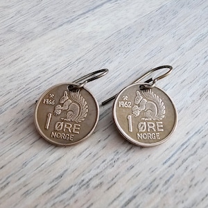 May include: A pair of earrings made from vintage Norwegian 1 øre coins featuring a squirrel design. The coins are dated 1962 and 1966.