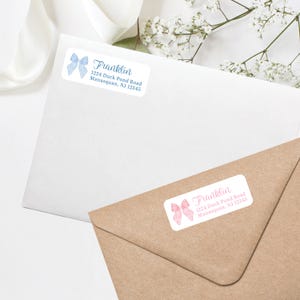 May include: White rectangular labels with watercolor bow designs in blue and pink. The labels feature the name "Franklin" in script font, along with an address: 1224 Duck Pond Road, Manasquan, NJ 12345.