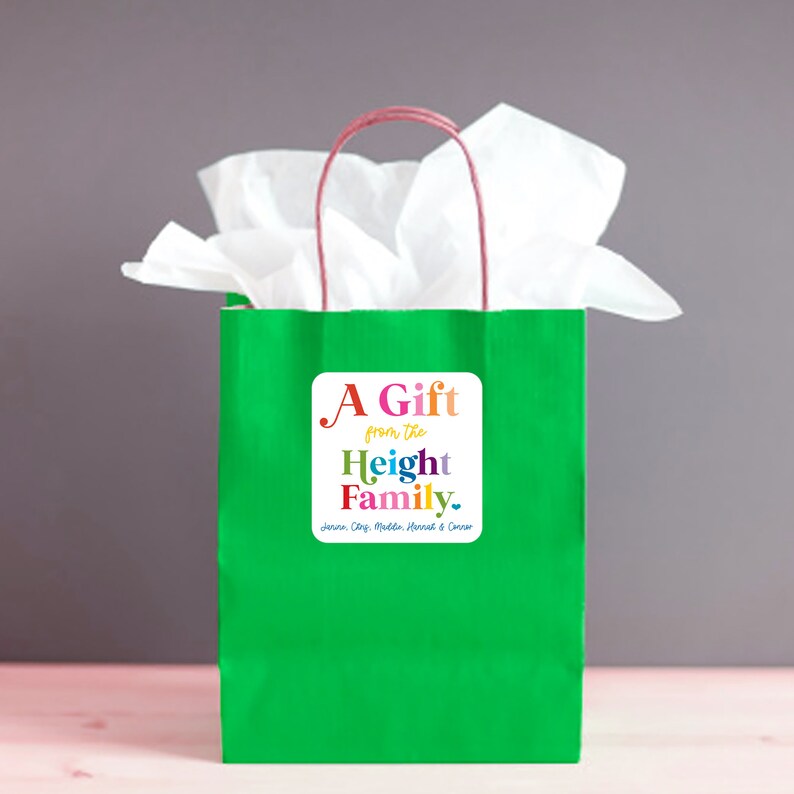 May include: A bright green gift bag with a white tissue paper and a red handle. A white square sticker on the front reads "A Gift from the Height Family" in colorful text. The names Jenna, Cary, Madden, Hannah & Connor are listed below.