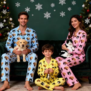 Könnte beinhalten: Familie in passenden Pyjamas mit Hunde- und Katzenmuster. Die Pyjamas sind hellblau, rosa und gelb mit vertikalen Streifen. Ein Welpe und eine schwarz-weiße Katze werden von den Erwachsenen gehalten. Ein Kind hält eine Glocke. Weihnachtsbäume und Schneeflocken sind im Hintergrund.