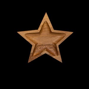 Peut inclure: Un bol en forme d'étoile en bois avec une finition naturelle veinée. Le bol a un intérieur profond et est posé sur un fond noir. Ce bol décoratif convient pour servir des collations ou comme élément décoratif.