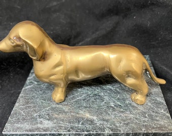 brass dachshund dog on marble stand