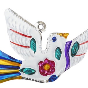 May include: A white metal dove ornament with colorful accents. The dove has red, teal, purple, yellow, and blue details. A pink flower is on the dove's chest. The wings are outstretched, and the dove has a silver loop for hanging.