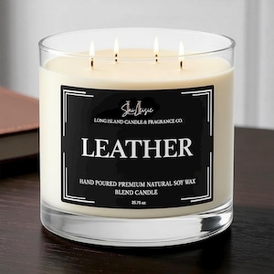 K&ouml;nnte beinhalten: Eine gro&szlig;e, runde Kerze in einem transparenten Glas. Die Kerze ist elfenbeinfarben mit vier Dochten. Ein schwarzes Etikett mit wei&szlig;em Text lautet "LEATHER" und "LONG ISLAND CANDLE & FRAGRANCE CO.". Die Kerze wiegt 1013 Gramm.