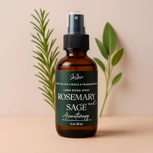May include: A brown glass bottle of linen room spray with a black spray nozzle. The label reads "Rosemary and Sage Aromatherapy" and "4 oz 118 ml". Green sprigs of rosemary and sage are in the background.