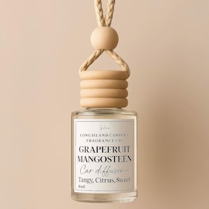 May include: A clear glass car diffuser bottle with a beige wooden cap and a beige rope hanger. The bottle is labeled "GRAPEFRUIT MANGOSTEEN Car diffuser - Tangy, Citrus, Sweet 8ml".