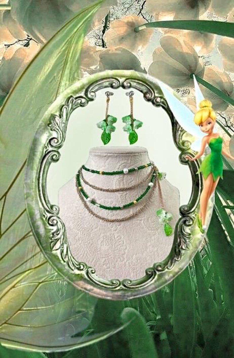 Puede incluir: Un conjunto de collar y pendientes con detalles verdes y dorados. El collar tiene m&uacute;ltiples hilos con cuentas verdes y cadenas doradas. Los pendientes tienen un dise&ntilde;o floral con hojas verdes. Las joyas se exhiben en un maniqu&iacute;.