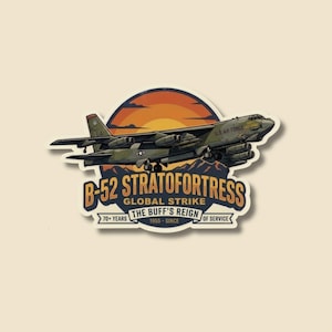 May include: A sticker featuring a B-52 Stratofortress bomber in flight against a sunset backdrop. The design includes text that reads "B-52 Stratofortress Global Strike" and "The Buff's Reign" with "70+ Years of Service."