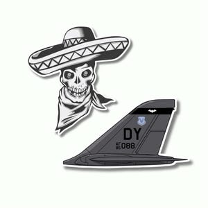 May include: Two stickers: a black and white illustration of a skull wearing a sombrero and a bandana, and a gray airplane tail with the text "DY 85 088" and a small emblem.