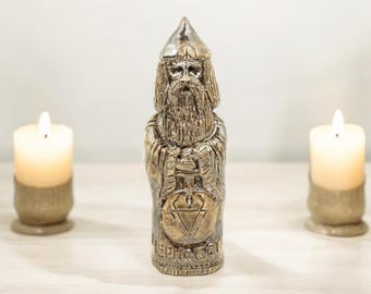 May include: A ceramic figurine of a bearded man wearing a pointed hat and holding a staff. The figurine is painted in gold and brown tones and has the word "LEPHAS" inscribed on the base.
