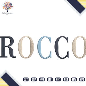 May include: An embroidered design of the name "ROCCO" in a serif font. The letters are in shades of navy, beige, and light blue. The image includes the "DigitalGraphics by ALI" logo and embroidery file formats.